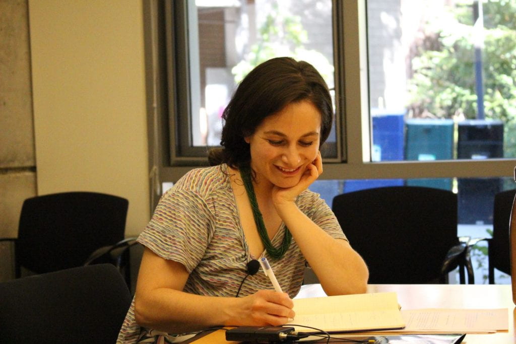 Elizabeth Marcus writing in a notebook during her colloquium talk